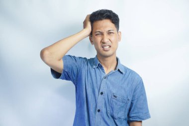 Yakışıklı delikanlı çünkü umutsuz ve stresli baş ağrısı acı izole arka plan üzerinde ağrı ve migren. Ellerini kafasına.