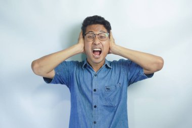 Şaşırmış / şaşırmış genç iş adamı el ele tutuşuyor ve ağzını açık tutuyor. Baş ağrısı ya da stres. İnsani duygular, yüz ifadeleri, duygu konsepti