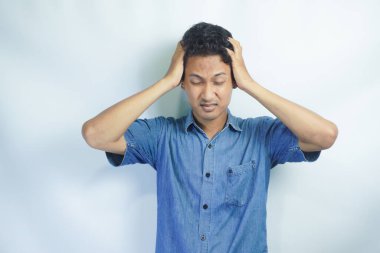 Yakışıklı delikanlı çünkü umutsuz ve stresli baş ağrısı acı izole arka plan üzerinde ağrı ve migren. Ellerini kafasına.