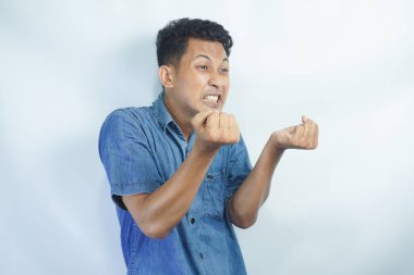 Annoyed and angry man raising hands and clench teeth outraged, stare pissed-off at camera, going to kill someone, standing on white background.