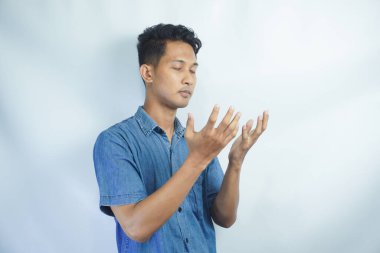 Stüdyoda beyaz bir arka planda Tanrı 'dan mucize ya da yardım isteyen bir adamla dua, inanç ve maket. Güven, din ve ruhani inanç için dua eden genç ve yakışıklı bir erkek.