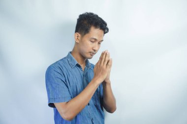 Stüdyoda beyaz bir arka planda Tanrı 'dan mucize ya da yardım isteyen bir adamla dua, inanç ve maket. Güven, din ve ruhani inanç için dua eden genç ve yakışıklı bir erkek.