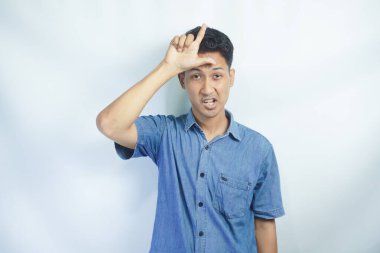 Acımasız, kaba, kötü okul çocuğunun fotoğrafı beyaz renkli arka planda izole edilmiş levhanı kaybettiğini gösteren küstah yüz ifadesi.