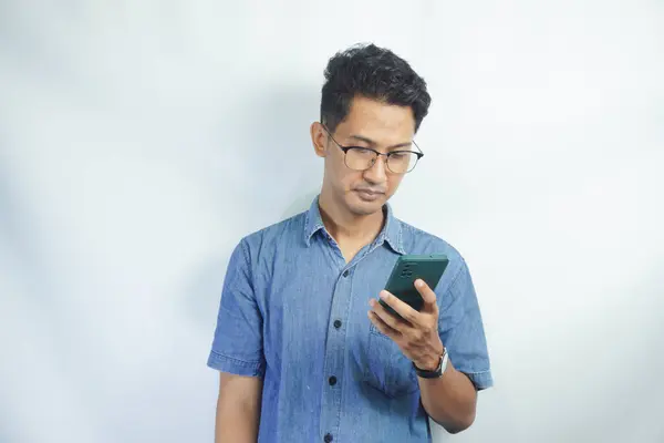 Homme Asiatique Chemise Bleue Regarde Sérieusement Son Téléphone Portable Porte — Photo