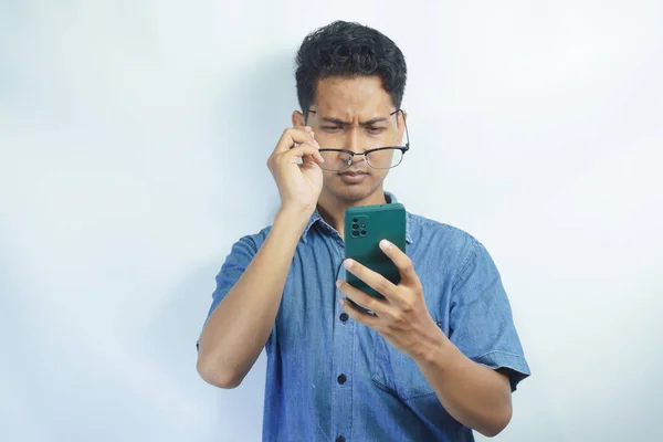 Hombre Asiático Con Una Camisa Azul Mira Seriamente Teléfono Celular — Foto de Stock