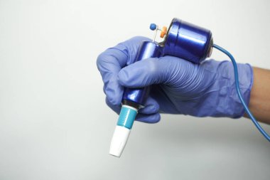 Sanatçının elindeki dövme makinesi beyaz arkaplanda izole edildi