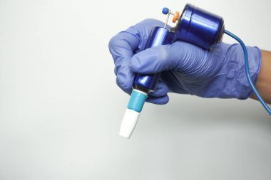 Sanatçının elindeki dövme makinesi beyaz arkaplanda izole edildi