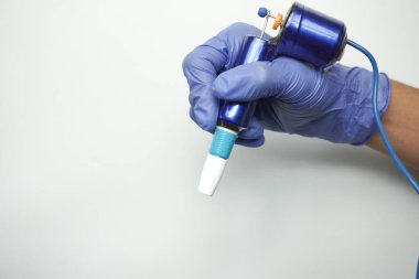 Sanatçının elindeki dövme makinesi beyaz arkaplanda izole edildi