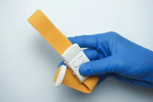 Γιατρός Φορώντας Μπλε Ιατρικά Γάντια Κρατώντας Ένα Κίτρινο Αιμοστατικό Επίδεσμο — Φωτογραφία Αρχείου