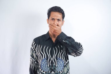 Ağzını kapatan batik tişört giyen genç adam şaşırdı.