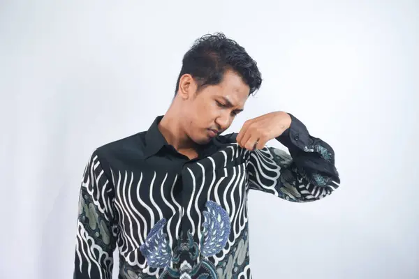 Een Man Ruikt Zijn Onderarm Door Zijn Batik Shirt Controleren — Stockfoto