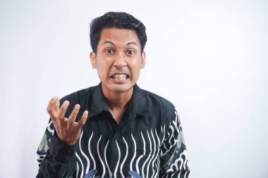 İzole edilmiş beyaz arka planda Batik gömlekli Asyalı adamın kızgın ve kızgın yüzü..