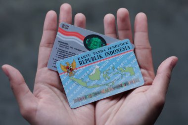 Yogyakarta, 1 Haziran 2023. Endonezya ehliyeti ya da Surat Ijin Mengemudi 'yi (SIM) tutan bir el. SIM C ve KTP ile el ele tutuşuyorlar.