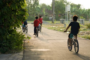 Klaten, 01 Temmuz 23. Öğleden sonra bisiklet oynayan bir grup çocuk.