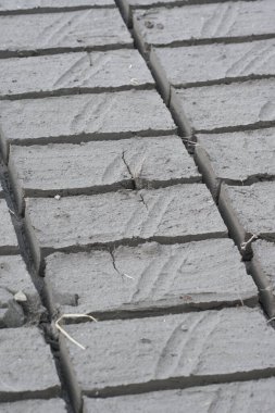 Kırmızı tuğlayı geleneksel yollarla yapma süreci açık alanda güneşin ışınlarının altında, kilden çıkan kırmızı tuğla kuruyordu.