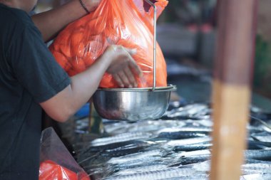 Çalışanlar tavuk parçalarını paketleyip satmak için tartıyorlar..