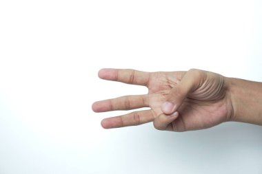 Beyaz arka planda parmaklarını gösteren beyaz tenli bir gencin eli üç parmağı gösteriyor.