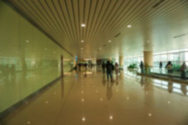Havaalanındaki koridordan geçen insanların bulanık görüntüsü.