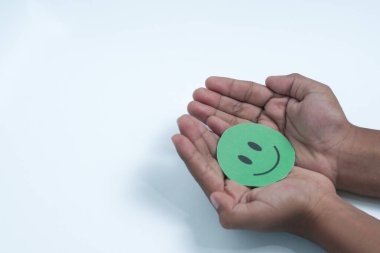 Ellerinde yeşil gülen surat, iyi geri bildirim notu, olumlu müşteri değerlendirmesi, deneyim, tatmin anketi, gülümseyen akıl sağlığı, çocuk sağlığı, beyaz arka planda dünya ruh sağlığı günü