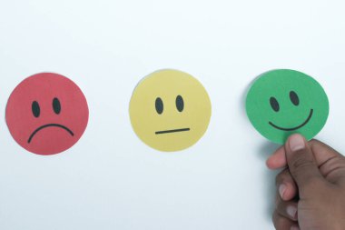 Elle seçilen yeşil gülücük kağıt kesiği, geri bildirim notu ve olumlu müşteri değerlendirmesi, memnuniyet anketi, zihinsel sağlık değerlendirmesi, iyi hissetmek, dünya akıl sağlığı günü konsepti