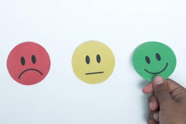 Elle seçilen yeşil gülücük kağıt kesiği, geri bildirim notu ve olumlu müşteri değerlendirmesi, memnuniyet anketi, zihinsel sağlık değerlendirmesi, iyi hissetmek, dünya akıl sağlığı günü konsepti