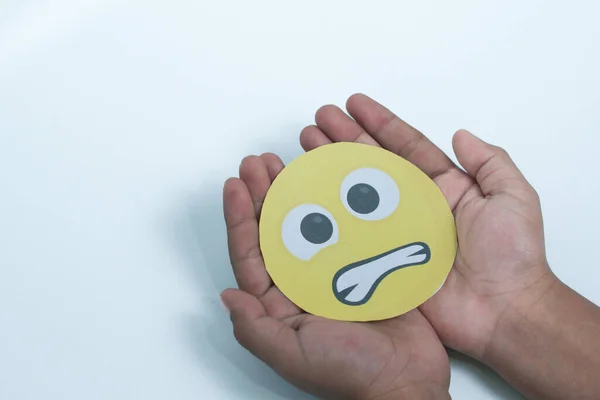 Hand holding angry emoticon paper, feedback rating, customer review, emotional intelligence, emotional control balance, mental health assessment, bipolar disorder concept