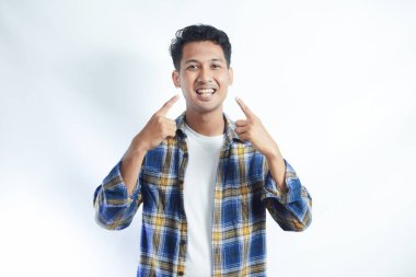 Çekici Asyalı adam, gülümserken dişlerini gösteriyor.