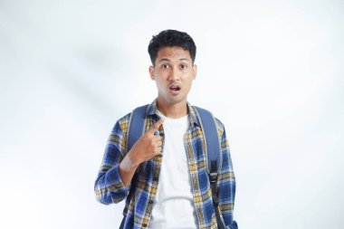 Sırt çantasıyla kendini gösteren Asyalı genç bir öğrenci beyaz arka plandaki ani başarının şokuna uğradı.