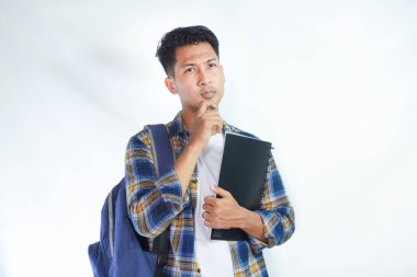 Sırt çantalı genç Asyalı öğrenciler ellerinde defterlerle beyaz arka planda izole edilmiş bir şeyi düşünüyorlar. Lise üniversite konsepti eğitimi