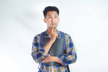 Sırt çantalı genç Asyalı öğrenciler ellerinde defterlerle beyaz arka planda izole edilmiş bir şeyi düşünüyorlar. Lise üniversite konsepti eğitimi