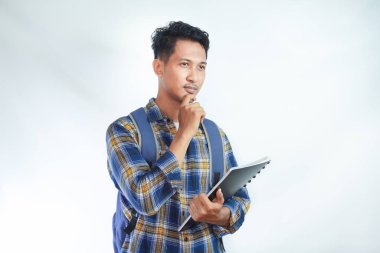 Sırt çantalı genç Asyalı öğrenciler ellerinde defterlerle beyaz arka planda izole edilmiş bir şeyi düşünüyorlar. Lise üniversite konsepti eğitimi