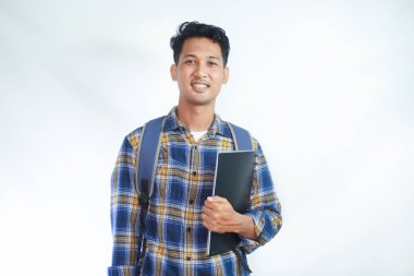 Sırt çantalı mutlu Asyalı öğrenciler okula yalnız beyaz arka planda kitap taşıyorlar. Lise üniversite konsepti eğitimi