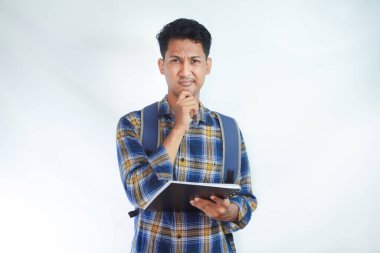 Sırt çantalı genç Asyalı öğrenciler ellerinde defterlerle beyaz arka planda izole edilmiş bir şeyi düşünüyorlar. Lise üniversite konsepti eğitimi