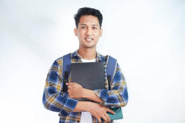 Sırt çantalı mutlu Asyalı öğrenciler okula yalnız beyaz arka planda kitap taşıyorlar. Lise üniversite konsepti eğitimi