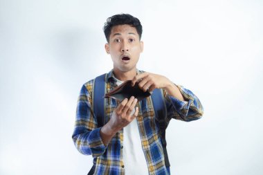 Beyaz arka planda cüzdanını açarken sırt çantalı, şaşırmış ve üzgün bir ifadeyle Asyalı genç bir erkek öğrencinin portresi. Lise üniversite konsepti eğitimi