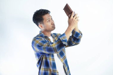 Yetişkin Asyalı adam endişeli bir ifadeyle boş cüzdanını gösteriyor.