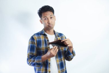 Yetişkin Asyalı adam endişeli bir ifadeyle boş cüzdanını gösteriyor.