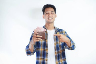Yetişkin Asyalı adam elinde tuttuğu parayı gösterip gülümsüyor.