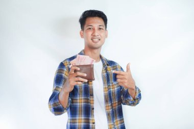 Yetişkin Asyalı adam elinde tuttuğu parayı gösterip gülümsüyor.