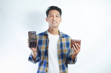 Sırt çantalı neşeli Asyalı öğrenci beyaz arka planda boş cep telefonu ve cüzdan gösteriyor. Lise üniversite konsepti