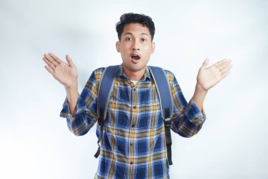 Sırt çantalı, sıradan kıyafetler giyen 20 'li yaşlardaki Asyalı öğrenci beyaz arka planda izole edilmiş harika bir şey olduğunu söylüyor. Lise üniversite konsepti eğitimi