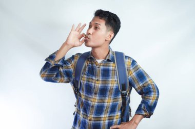 Sırt çantalı genç Asyalı öğrenci iyi bir zevk göstergesi, Bellissimo jesti ve beyaz arka planda izole edilmiş parmakları öpüyor. Lise üniversite konsepti