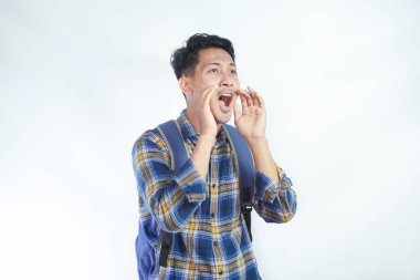 Heyecanlı Asyalı genç bir öğrenci günlük kıyafetler ve sırt çantası giyiyor. Beyaz arka planda ağzı kapalı satış indirimleri ile ilgili sıcak haberler bağırıyor. Lise üniversite konsepti