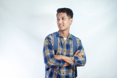 Sırt çantalı neşeli Asyalı genç bir erkek öğrenci boş alana bakıyor, beyaz arka planda izole edilmiş okul kayıt için yeni bir reklam. Lise üniversite konsepti