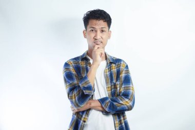 Sarı flanel tişört giyen yetişkin bir Asyalı düşünme hareketi gösteriyor.