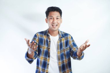 Yetişkin Asyalı adam tebessüm etmek için kollarını açarken heyecanla gülümsüyor.