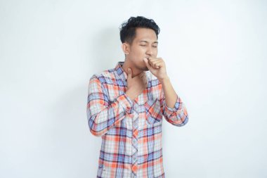 Yetişkin Asyalı adamın boğazı ağrıdı ve öksürdü.