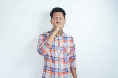 Stüdyonun beyaz izole edilmiş arka planında esneyen yorgun ve uykulu genç adamın portresi. Sıkıcı erkek uykulu hisseder, yorgun hisseder, ağzını açar, gözlerini kapatır..