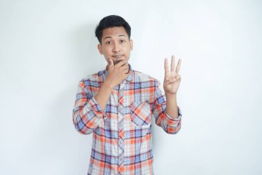 Yetişkin bir Asyalı üç parmağıyla işaret veriyor.