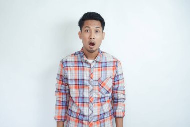 Yetişkin Asyalı adam şok olmuş bir ifadeyle kameraya bakıyor.